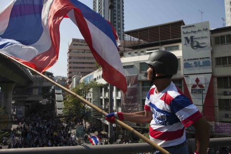 Bangkok, Thaïlande,  Janv.2014 Un manifestant anti-gouvernemental agitant le drapeau national bleu-blanc-rouge, symbole des manifestations.
