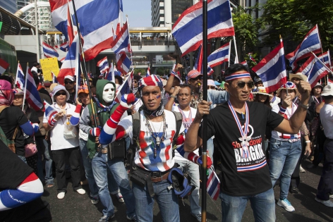 Bangkok, Thaïlande,  Janv.2014 Tête du cortège des manifestants anti-gouvernementaux sur Sathorn Road.  Tous porte les couleurs nationales bleu-blanc-rouge, symboles du mouvement d'opposition. On entend également les sifflets qui sifflent dans les rues de manière continus.