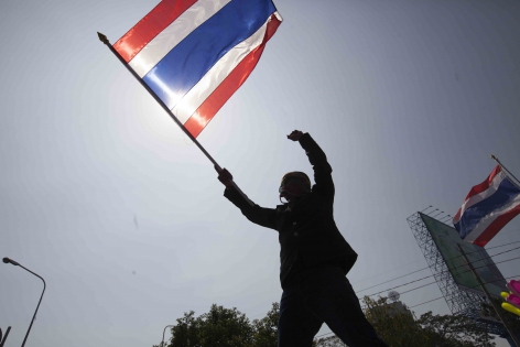 Bangkok, Thaïlande,  Janv.2014 Un manifestant anti-gouvernemental brandit le drapeau national, symbole du mouvement de révolution populaire pendant une marche du  mouvement sur Sathorn Road.
