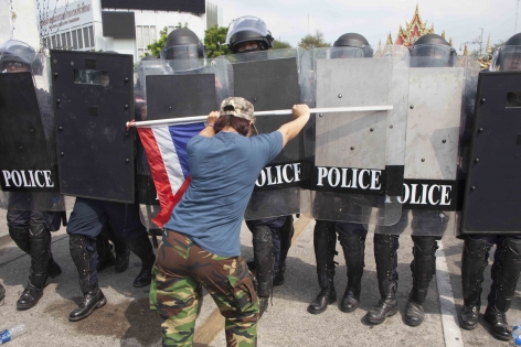 Bangkok, Thaïlande,  Févr.2014 L'opposition réussit tout de même à repousser les forces de l'ordre et à conserver sa position à Government House. Une jeune femme force les troupes de police à battre en retraite.