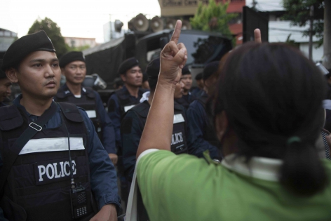 Bangkok, Thaïlande, Mai 2014 Une manifestante anti-coup d'Etat  insulte les militaires postés derrière les rangs des forces de police positionnés sur la place de Democracy Monument.